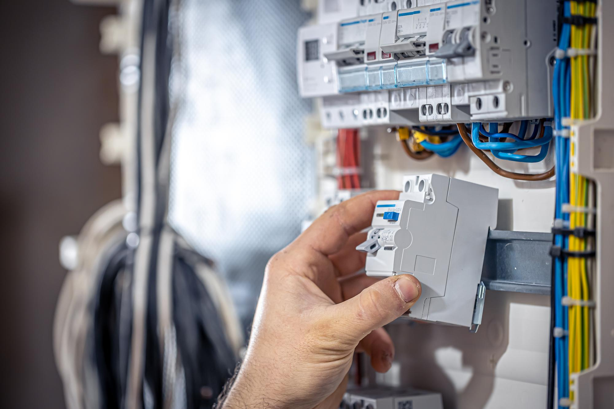 electricien qui installe disjoncteur dans tableau électrique