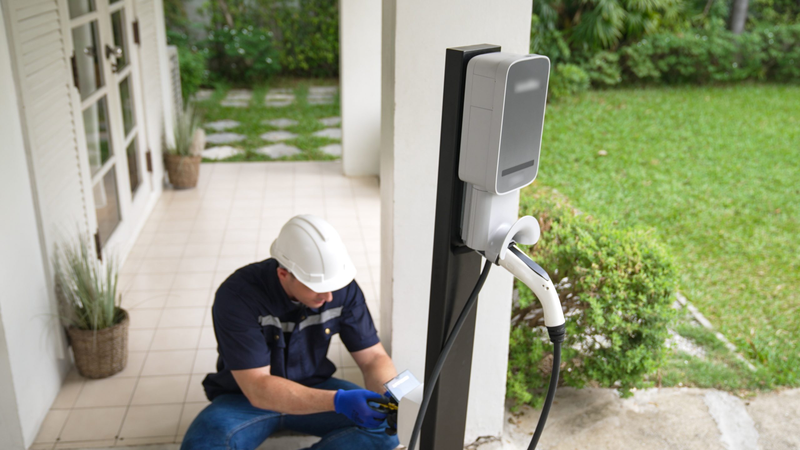 électricien qui installe une borne de recharge pour véhicule électrique